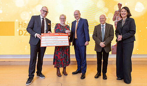 The picture shows several people presenting the prize to Alison Goate.