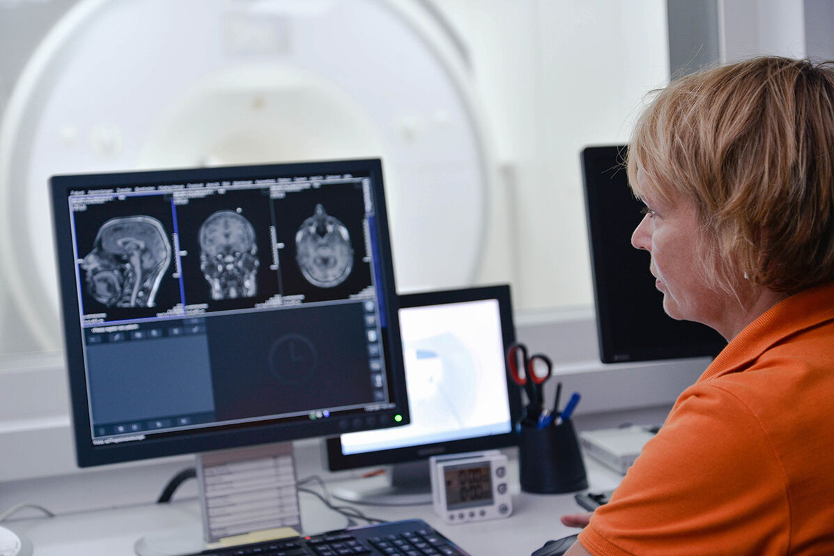 Person sitting in front of monitor in MRI.