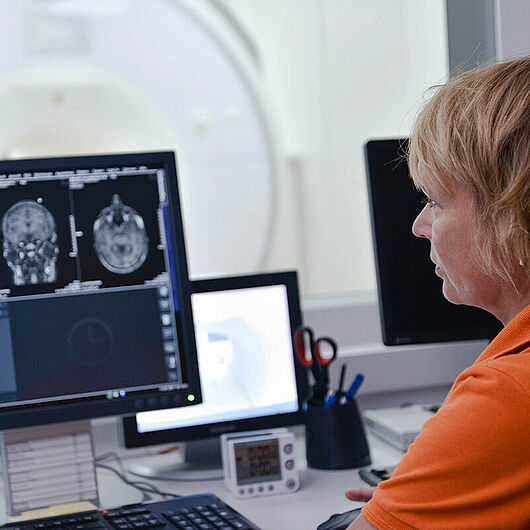 Person sitting in front of monitor in MRI.