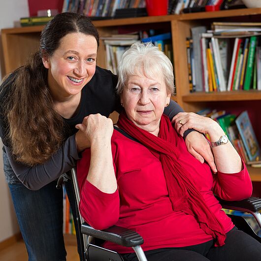 Symbolbild zeigt eine junge Frau, die eine ältere Dame umarmt.