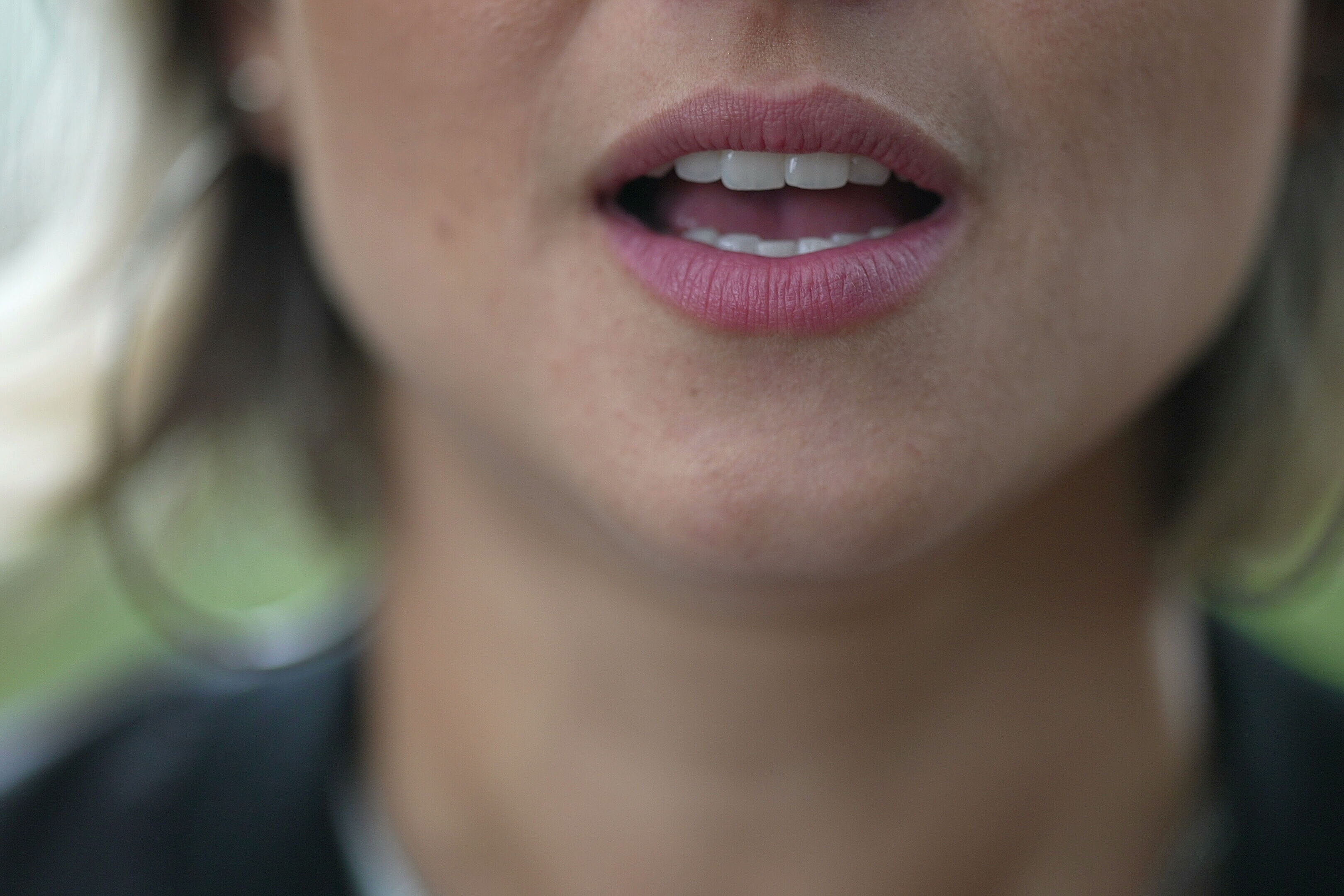 Image shows detail of mouth of talking woman