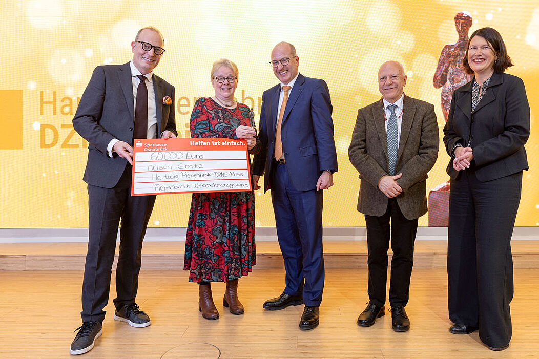 The picture shows several people presenting the prize to Alison Goate.