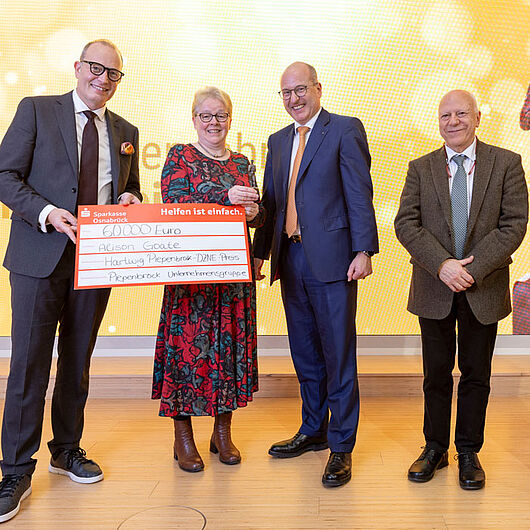 The picture shows several people presenting the prize to Alison Goate.
